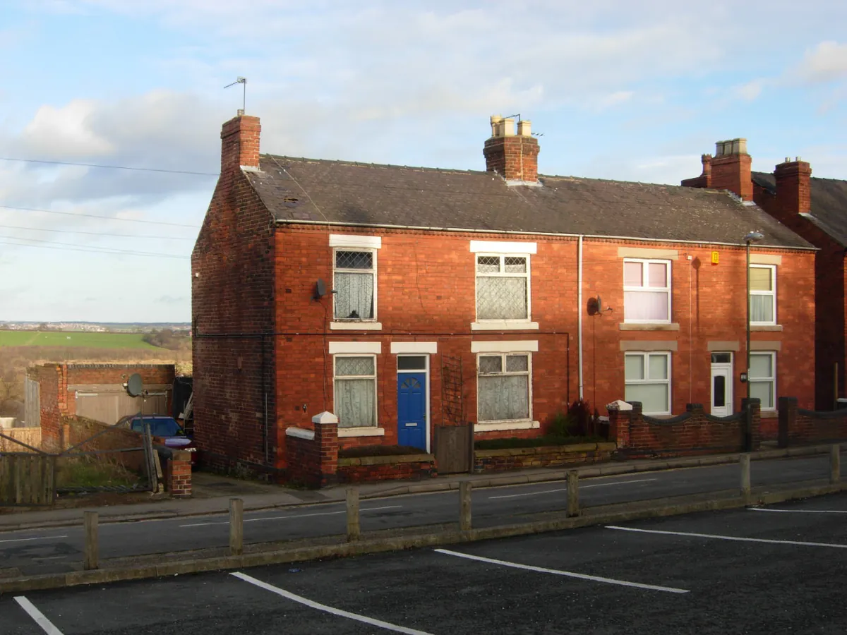 A pair of red-brick terraced houses on Whysall Street in Heanor, with fields beyond