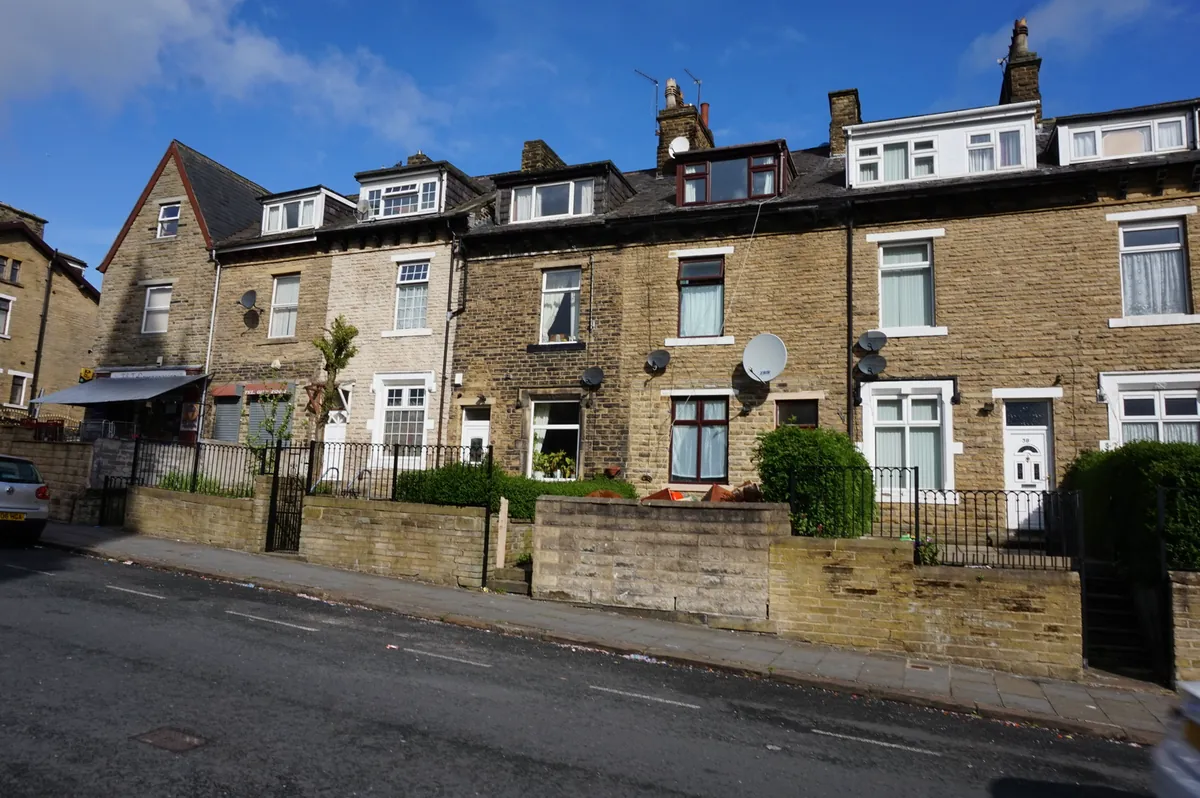 Stone terraced houses with dormer windows on Victor Road in Manningham, Bradford