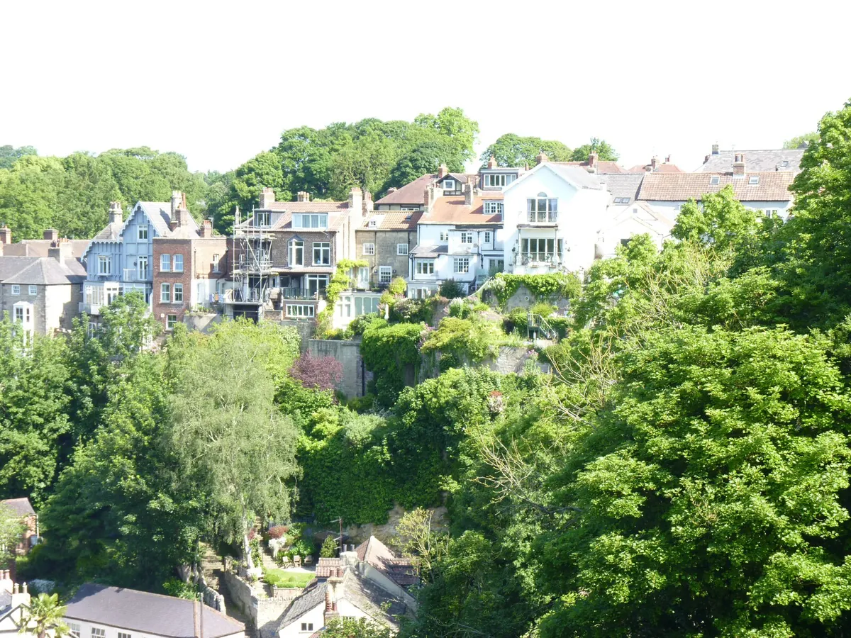 Houses stacked up the wooded slope above the River Nidd in Knaresborough
