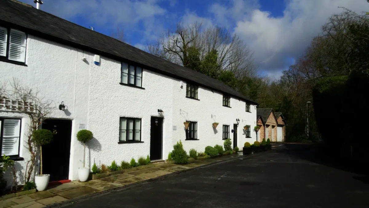 A row of white-painted cottages with black doors on Mill Brow in Worsley