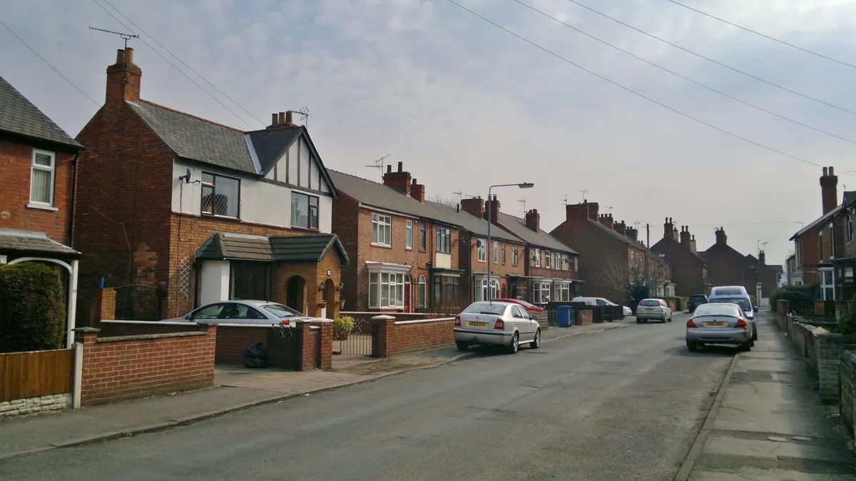 Red-brick semi-detached houses with low front walls along Grove Lane in Retford